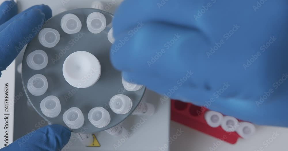 Wall mural lab technician loads the samples with the sample into the laboratory centrifuge