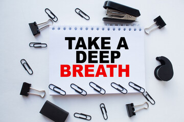 Notepad with inscriptions TAKE A DEEP BREATH on a white background. business concept.