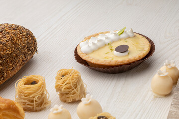 detail of an elegant cake with cream next to small appetizers in the form of nests, studio