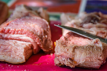 Raw piece of pork belly and knife on a cutting board