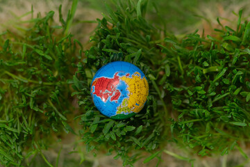 A globe on the lush green grass. Earth Day.