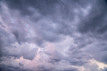 heavy rain clouds, cumulus clouds move across the sky. soft pink and dark blue mix