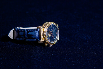 old watch, retro watch on dark blue background, watch in the dark, golden watch on blue