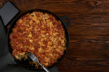Macaroni with cheese  in a pan on an old wooden table.