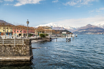 The lakeside promenade of Colico with the snow-capped Alps in the background - obrazy, fototapety, plakaty