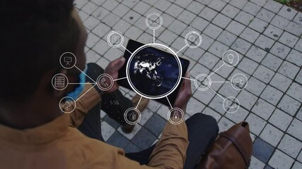 Animation of global digital interface and icons with businessman in face mask using tablet in street - Powered by Adobe