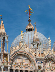 Decoration elements at roofs and cupolas of Basilica San Marco in Venice, Italy, at sunny day and deep blue sky