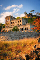 Abandoned ruin building of Termas Radium Hotel Serra da Pena in Sortelha with beautoful colorful trees at sunset, Portugal