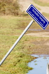 Dutch blue forbidden access sign on pole that is skewed in a nature area