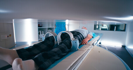 Multiethnic doctors releasing aged patient from MRI machine