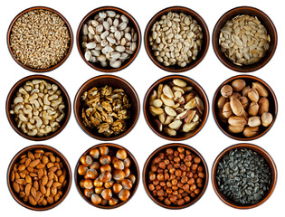 Peanuts, cashews, hazelnuts, almonds, walnuts, pecans, Brazil nuts, sunflower seeds, pumpkin seeds, pistachios close up. Nuts in clay bowls isolated on a white background.