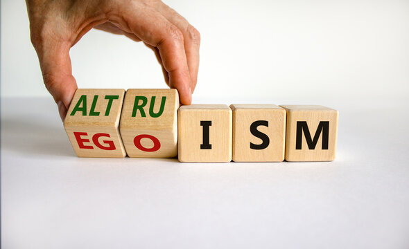 Altruism or egoism symbol. Businessman turns wooden cubes and changes the word 'egoism' to 'altruism'. Beautiful white background, copy space. Business, psychological and altruism or egoism concept.