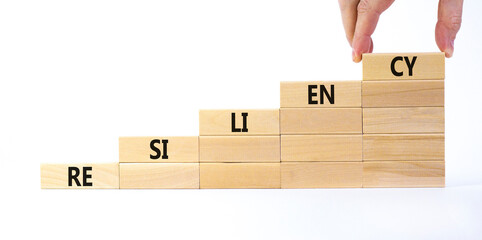 Resiliency symbol. Wooden blocks with word 'resiliency' stacking as step stair on beautiful white background, copy space. Businessman hand. Business and resiliency concept success process.