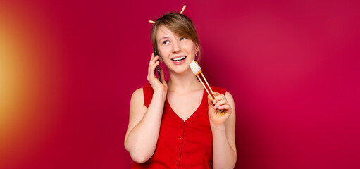Banner. Young girl, red shirt hold in hand sushi roll served chopsticks. Japanese food call delivery using smartphone isolated on red background studio portrait. People, food, lifestyle concept
