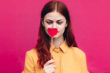 pretty woman in shirt holding heart on stick on pink background Copy Space