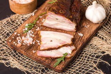 A piece of baked meat with layers of bacon, cut from the bottom of a pork carcass, along with the skin.