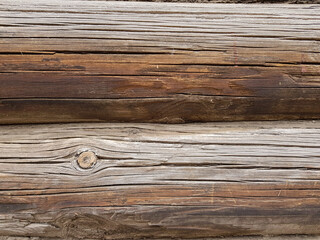 close-up as a background - the texture of an abandoned wooden house, a wall of old wooden blackened beams with slots, horizontally folded, connected by tow. In the countryside, outside the city. 