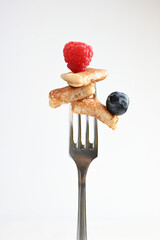 pancake on a fork with strawberries on white background