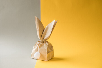 Easter bunny paper gift egg wrapping DIY idea on colorful background. Minimal easter concept, flat...