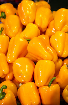 Golden yellow bell peppers laid in grocery shop, yellow bell pepper texture.
