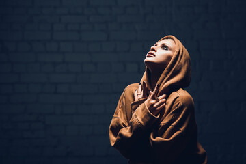 Studio portrait of a girl in a hoodie on a dark background