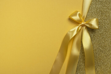 Golden gift shiny card, certificate or texture gift box with yellow ribbon bow. Christmas, new year, birthday, anniversary or sale background. Top view, flat lay, copy space, template for design