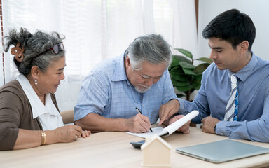 Obraz premium An insurance agent offers health insurance for Asian elderly couples, Finance staff present and close real estate sales.