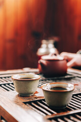Obraz na płótnie Canvas Chinese tea ceremony.Ceramic tea bowl on a wooden chaban.
