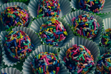 Small handmade sweet doughs decorated with multi-colored sprinkles. Food for celebrations and birthdays.