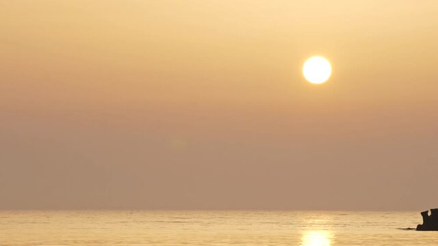 The sun rising over the Black Sea. Calm orange sea at sunrise