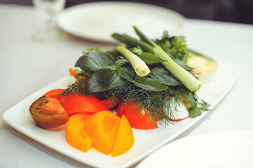 Fresh vegetable salad with radish, cucumber, bell pepper, tomatoes and herbs in a ceramic bowl restaurant dish. Selective focus