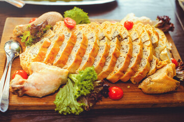 beautiful chicken and mushroom pie with herbs, tomatoes and chicken legs on a wooden board in a restaurant. Selective focus, close-up