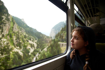 Teenage girl looking smiling out of a train window