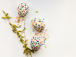 Three Easter eggs are drawn with red, yellow, blue gouache on a white background.