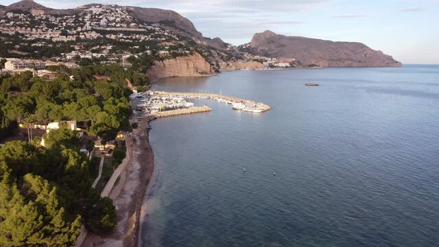 Aerial view of the harbor at sunset as jet skis come in.
