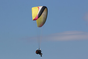 Tandem Paraglider flying wing in a blue sky