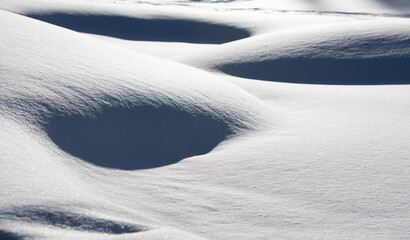 shadows in snow mounds winter landscape of fresh snow drifts on cold winter day peaceful and quiet hills of white horizontal format winter background room for type serenity mood