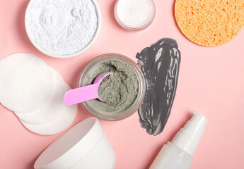 An open cosmetic jar, against the background of a smeared cream or cosmetic face mask. Purifying and moisturizing clay mask. Top view, flat lay