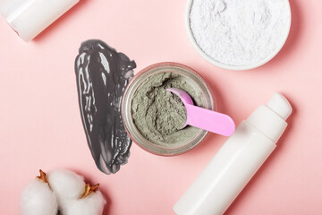 An open cosmetic jar, against the background of a smeared cream or cosmetic face mask. Purifying and moisturizing clay mask. Top view, flat lay