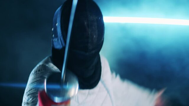 Fencer in a protection mask is practicing with a foil