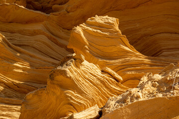 A sedimentary sandstone formation with vibrating yellow and orange colors  on a warm sunny day in the isalnd of Mallorca Spain