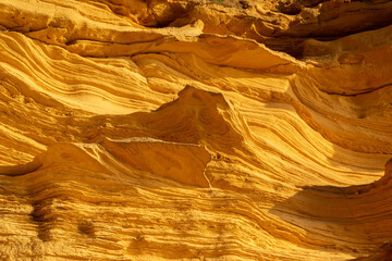 A sedimentary sandstone formation with vibrating yellow and orange colors  on a warm sunny day in the isalnd of Mallorca Spain
