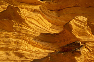 A sedimentary sandstone formation with vibrating yellow and orange colors  on a warm sunny day in the isalnd of Mallorca Spain