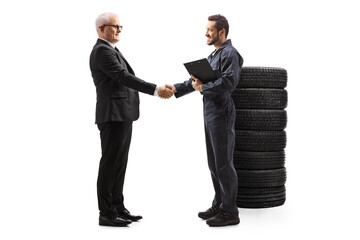 Full length profile shot of an auto mechanic shaking hands with a mature businessman