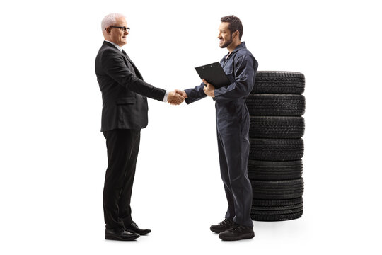 Full length profile shot of an auto mechanic shaking hands with a mature businessman