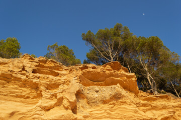 A sedimentary sandstone formation with vibrating yellow and orange colors  on a warm sunny day in the isalnd of Mallorca Spain