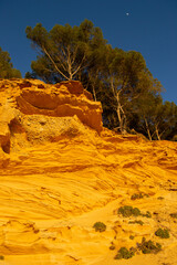 A sedimentary sandstone formation with vibrating yellow and orange colors  on a warm sunny day in the isalnd of Mallorca Spain