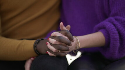 Obraz na płótnie Canvas Diverse interracial young couple joining hands outside. Diversity concept union