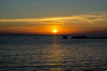 Sunset at Mallorca beach spain with a canoe kayak in the distance with the soft light of the evening sun during the golden hour