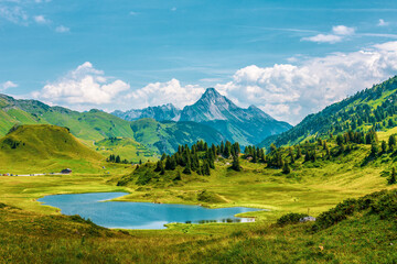 Fototapeta na wymiar The lake Kalbelesee, a high mountain lake on the Hochtann Mountain Pas in the Austrian state of Vorarlberg.